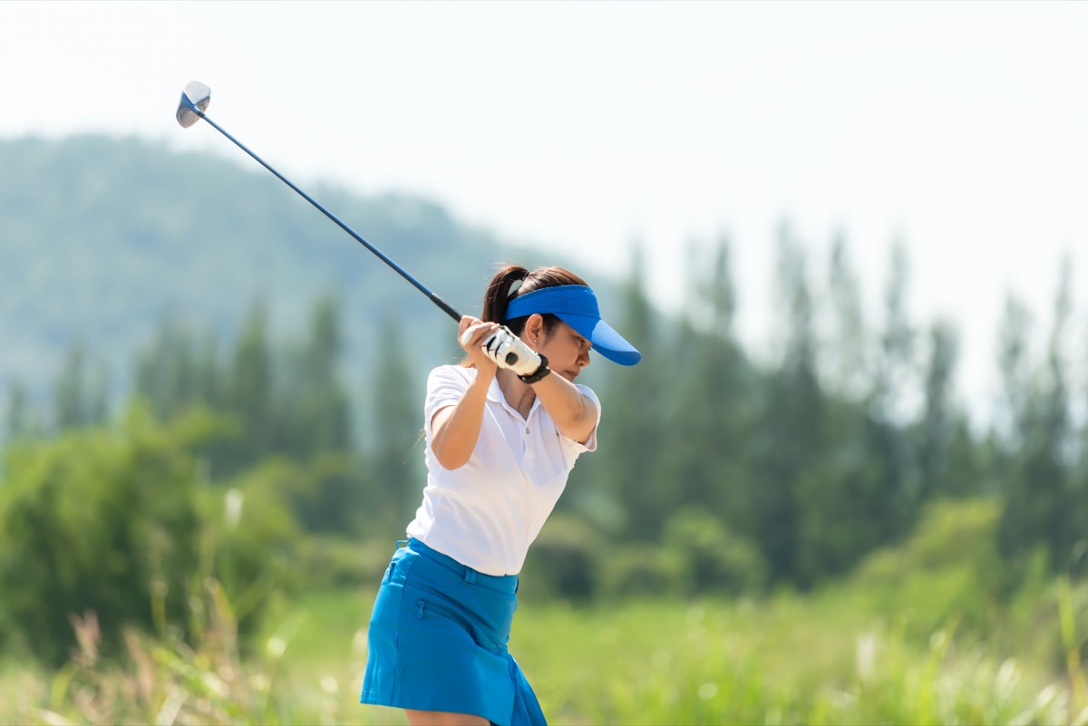 ポロシャツとスカートでスイングする女性