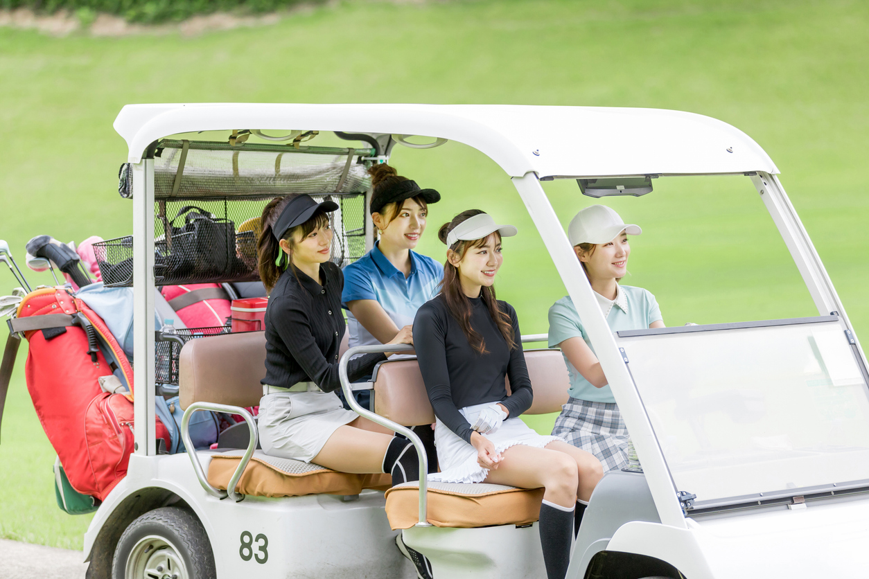 コーチに指導を受けながらスイング練習する女性ゴルファー